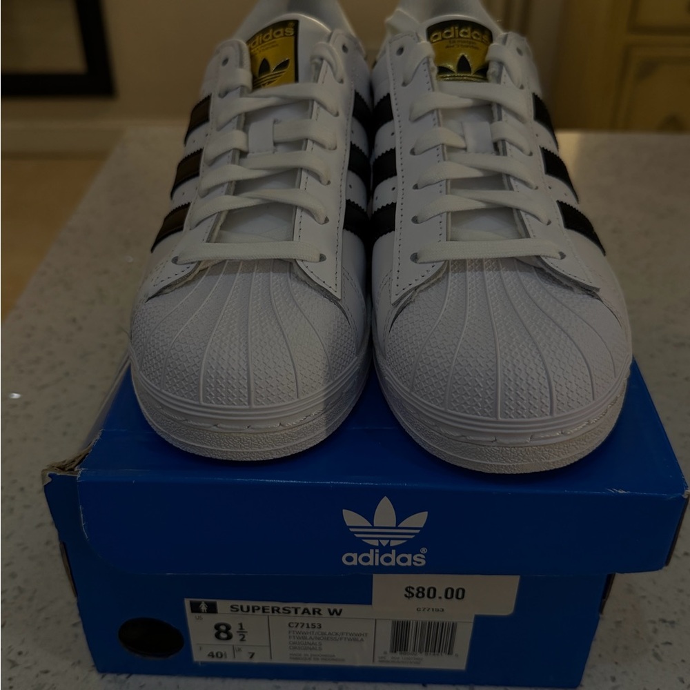 adidas Women’s White Sneakers with Black Stripes and Gold Tongue Logo